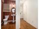 A powder room with an oval mirror and dark red wallpaper at 3901 Cherry Ridge Blvd, Decatur, GA 30034
