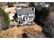 Aerial view of a home with a tiered backyard, including a patio, lush landscaping, and mature trees at 539 Wintergreen Way, Canton, GA 30115