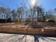 Well-maintained backyard with a wooden retaining wall and mature trees for privacy at 705 Bridge Se Ln, Smyrna, GA 30082