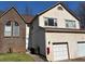 Two-story townhome with brick and siding exterior, attached garage, and manicured front yard at 705 Bridge Se Ln, Smyrna, GA 30082