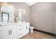 Charming bathroom featuring a double vanity, modern fixtures, wood look tile, and elegant mirrors with accent lighting at 1147 Oakland Sw Dr, Atlanta, GA 30310