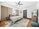 Spacious main bedroom with wood accent wall, tray ceiling, ceiling fan, and ensuite bathroom at 1147 Oakland Sw Dr, Atlanta, GA 30310