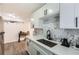 Updated kitchen features white cabinets, quartz countertops, stylish backsplash, and stainless steel sink at 1284 Piedmont Ne Ave # 12, Atlanta, GA 30309