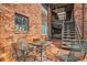 Charming outdoor patio with brick floor, metal seating, and staircase to the upper level at 1284 Piedmont Ne Ave # 12, Atlanta, GA 30309