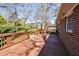 Back deck featuring a brick house, brown wooden boards, and a fenced yard at 2780 Eastfield Se Rd, Smyrna, GA 30080