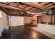 Basement with dark flooring, exposed wood ceiling, and a white garage door providing extra utility at 2780 Eastfield Se Rd, Smyrna, GA 30080