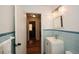 Bathroom with white sink, blue tiled walls, white fixtures and a view into the hallway at 2780 Eastfield Se Rd, Smyrna, GA 30080