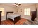 Bedroom with hardwood floors, two windows with sheer curtains, and a queen size bed with a blue pattern comforter at 2780 Eastfield Se Rd, Smyrna, GA 30080