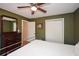 Olive-green bedroom features a ceiling fan, wood-look walls, and a matching dresser with a mirror above at 2780 Eastfield Se Rd, Smyrna, GA 30080