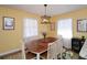 Bright dining room with a wood table, modern lighting, and two large windows at 2780 Eastfield Se Rd, Smyrna, GA 30080