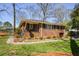 View of the brick home featuring an inviting front porch and nicely landscaped yard at 2780 Eastfield Se Rd, Smyrna, GA 30080