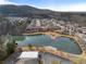 Serene aerial view of a community pond surrounded by lush greenery, homes, and a mountain backdrop at 348 Lauren Ln, Woodstock, GA 30188