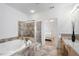 Bright bathroom featuring a double sink vanity, tiled floors, a soaking tub, and a glass door shower at 348 Lauren Ln, Woodstock, GA 30188