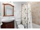 A functional bathroom featuring a wooden vanity, toilet, mirror and floral curtain at 348 Lauren Ln, Woodstock, GA 30188