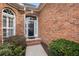 Close-up of a brick home's front entrance with a black door and trimmed green shrubs at 348 Lauren Ln, Woodstock, GA 30188