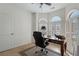 An office with hardwood floors, plantation shutters, and a wooden desk with a black office chair at 348 Lauren Ln, Woodstock, GA 30188