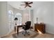 An office with hardwood floors, a ceiling fan, plantation shutters, and a wooden desk with black office chair at 348 Lauren Ln, Woodstock, GA 30188