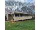 Home exterior featuring a long, covered porch with access to the backyard at 582 S Cherokee Rd, Social Circle, GA 30025