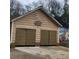 Two-car garage featuring dark doors and the house number above the door at 582 S Cherokee Rd, Social Circle, GA 30025