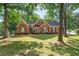 Charming brick home with black shutters, a manicured lawn, and mature trees in a peaceful setting at 587 Morgan Ct, Hampton, GA 30228