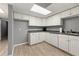 Basement kitchen featuring white cabinets, laminate flooring and grey paint at 587 Morgan Ct, Hampton, GA 30228