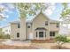 Tan two story home featuring a bay window, brick chimney, and small back patio at 105 Kentwood Springs Dr, Hampton, GA 30228