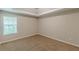 A carpeted bedroom with neutral paint, a large window, and tray ceiling for a calm and serene space at 105 Kentwood Springs Dr, Hampton, GA 30228