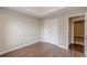 A well-lit bedroom with a tray ceiling, wood-look flooring and a closet presents a comfortable space at 105 Kentwood Springs Dr, Hampton, GA 30228