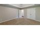 A serene bedroom with neutral carpeting, a closet and adjoining door promotes relaxation and privacy at 105 Kentwood Springs Dr, Hampton, GA 30228