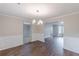 Dining room showcasing wainscoting, chandelier, hardwood floors, with an open-concept design at 105 Kentwood Springs Dr, Hampton, GA 30228