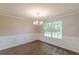 Well lit dining room featuring wainscoting and a modern chandelier over hardwood floors at 105 Kentwood Springs Dr, Hampton, GA 30228