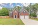 Beautiful brick home with an attached two-car garage, lush green lawn, and inviting curb appeal at 105 Kentwood Springs Dr, Hampton, GA 30228