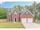 Charming two-story brick home featuring a two-car garage, manicured lawn, and a classic, welcoming facade at 105 Kentwood Springs Dr, Hampton, GA 30228