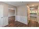 Hallway view showcases open floor plan with wainscoting, neutral paint, and durable flooring throughout at 105 Kentwood Springs Dr, Hampton, GA 30228