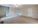 Spacious carpeted living room featuring a ceiling fan, staircase, and two entryways at 105 Kentwood Springs Dr, Hampton, GA 30228