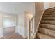 Carpeted staircase and entryway with decorative wainscoting and hardwood floors, providing a warm welcome at 105 Kentwood Springs Dr, Hampton, GA 30228
