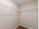 Walk-in closet featuring white wire shelving and wood-look flooring maximizes organization and style at 105 Kentwood Springs Dr, Hampton, GA 30228