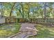 Scenic backyard featuring a wooden fence, mature trees, and a brick pathway at 116 Tallapoosa St, Temple, GA 30179