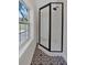 Modern shower with glass enclosure and black hardware with a patterned tile floor and window at 116 Tallapoosa St, Temple, GA 30179