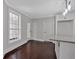 Bright dining area features dark hardwood floors, large windows, and access to kitchen and front porch at 116 Tallapoosa St, Temple, GA 30179