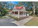 Charming home boasts a red roof, white picket fence, and nice landscaping at 116 Tallapoosa St, Temple, GA 30179