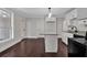 A kitchen features white cabinetry, granite countertops, dark wood floors and a center island at 116 Tallapoosa St, Temple, GA 30179