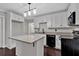 This kitchen features white cabinetry, granite countertops, black appliances and a center island at 116 Tallapoosa St, Temple, GA 30179