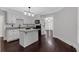 This kitchen features white cabinetry, granite countertops, dark wood floors and a center island at 116 Tallapoosa St, Temple, GA 30179