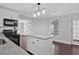 Bright kitchen with gray granite counters, white cabinets, stainless steel appliances, and access to dining area at 116 Tallapoosa St, Temple, GA 30179