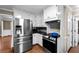 Kitchen featuring updated appliances, granite countertops, hardwood floors, and white cabinetry at 1190 Midland Way, Lawrenceville, GA 30043
