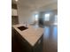 Kitchen island with marble countertop, dark cabinets, a sink, and a view of the living area fireplace at 270 Lakeside Pl, Canton, GA 30114