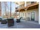 View of the outdoor covered patio showcasing comfortable seating and a tranquil wooded view at 341 Little Pine Ln, Woodstock, GA 30188
