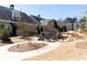 An inviting outdoor stone fire pit area with comfortable seating nestled amongst landscaped grounds and neighborhood homes at 341 Little Pine Ln, Woodstock, GA 30188