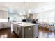 Open concept kitchen with stainless appliances, granite countertops, island, and connection to living and dining areas at 341 Little Pine Ln, Woodstock, GA 30188